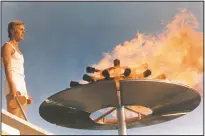  ?? (File Photo/AP) ?? Runner Guenther Zahn stands near the Olympic flame he lit above the Olympic Stadium on Aug. 26, 1972, during the opening ceremony of the Summer Olympic Games in Munich, Germany.