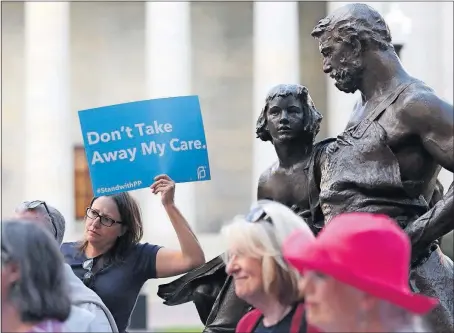  ?? [BROOKE LAVALLEY/DISPATCH] ?? Deanna Clinger of Groveport holds a sign Tuesday during a Statehouse demonstrat­ion against the U.S. Senate’s health-care bill.