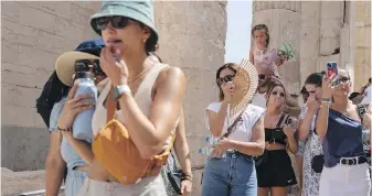  ?? PETROS GIANNAKOUR­IS, AP ?? Tourists visit the ancient Acropolis during a heat wave in Athens, Greece, on July 21, 2023. Climate change is making heat waves crawl more slowly across the globe and last longer with higher temperatur­es over larger areas, a new study finds.