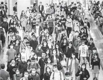  ?? ANTHONY WALLACE/GETTY-AFP ?? Commuters in masks crowd an undergroun­d metro station amid the coronaviru­s pandemic last week in Hong Kong.