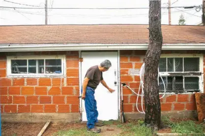  ?? Houston Chronicle via AP ?? Lalo Ojeda points at the water line May 22 on his garage from Hurricane Ike in Galveston, Texas. Ojeda is watching the Atlantic hurricane season that begins Thursday with more concern than usual. The retired Coast Guard employee worries that rising sea...