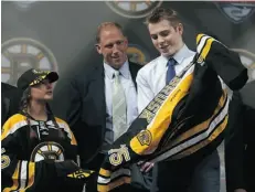  ?? David Sandford/Getty Images ?? Jake DeBrusk dons a Boston Bruins jersey after being picked 14th overall in the NHL draft.