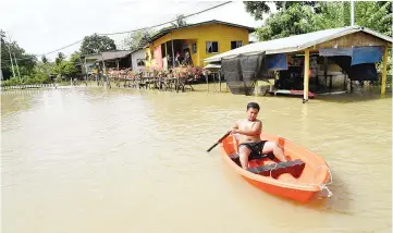  ??  ?? The boat is the only transport available after the floods hit Kota Belud. - Bernama photo