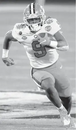  ?? BRIAN BLANCO/AP ?? Clemson running back Travis Etienne (9) evades a tackle by Notre Dame defensive lineman Adetokunbo Ogundeji as he runs for a touchdown on Dec. 19, 2020.