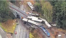  ??  ?? Cars from a derailed Amtrak train spilled onto Interstate 5 on Monday. JOHN FROSCHAUER/ AP