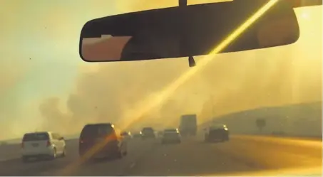  ?? Erin Allday / The Chronicle ?? A 500-acre grass fire on both sides of Interstate 580 on Alameda County’s Altamont Pass forced traffic to navigate a haze.