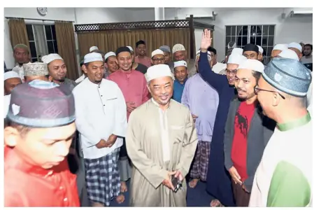  ??  ?? Early prayers: Sultan Abdullah (centre) sharing a light moment with fellow Muslims after performing the subuh prayers at Masjid Al-Imam Ash-Shafie in Kuantan.