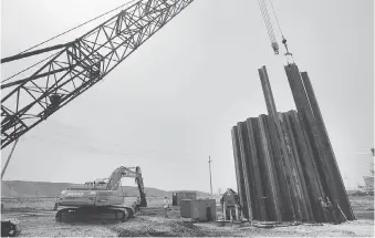  ??  ?? Crews work and heavy equipment work on framing for a sewage pumping station at the Canadian Plaza.