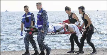  ?? JAPAN DEFENSE MINISTRY / ASSOCIATED PRESS ?? An injured sailor from the USS Fitzgerald is carried by U.S. military personnel (left) and Japanese Maritime Self-Defense Force members upon arriving at the U.S. Navy base in Yokosuka, Japan, on Saturday.