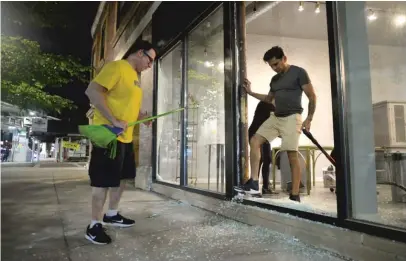  ?? SUN-TIMES FILE PHOTO ?? Owners of the Fashion Showroom on North Broadway clean up shattered glass from looting on June 1.