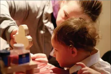  ?? JONATHAN TRESSLER — THE NEWS-HERALD ?? Three-year-old Journey Smart watches closely as her mother, Leah Smart, helps put some finishing touches on the wooden gingerbrea­d-man toy the pair made during the Santa’s Wild Workshop in the Woods event for children who have special needs Dec. 9 at...