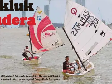  ??  ?? MUHAMMAD Faizzuddin (kanan) dan Muhammad Fikri Aqil membuat latihan perahu layar di Sungai Kuala Terengganu.