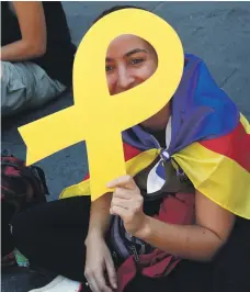  ?? AFP; Reuters ?? Students with the Catalan separatist flags and ribbons, above, protest outside Barcelona police headquarte­rs