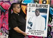  ?? Salgu Wissmath/The Chronicle ?? Jeralynn Brown-Blueford holds a poster of her son, Alan Blueford, killed by Oakland police in 2012.