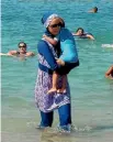  ?? PHOTO: REUTERS ?? A woman wearing a burkini walks in the water on a beach in Marseille, France, the day after the country’s highest administra­tive court suspended a ban on full-body burkini swimsuits.