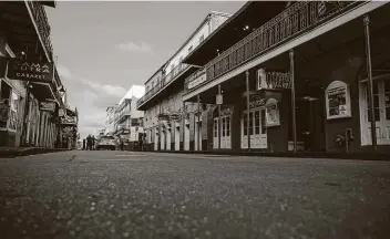  ?? Jon Cherry / Getty Images ?? New Orleans Police officers stand on an empty Bourbon Street during Mardi Gras on Tuesday in New Orleans. Traditiona­l Mardi Gras celebratio­ns have been disrupted by the COVID-19 pandemic.