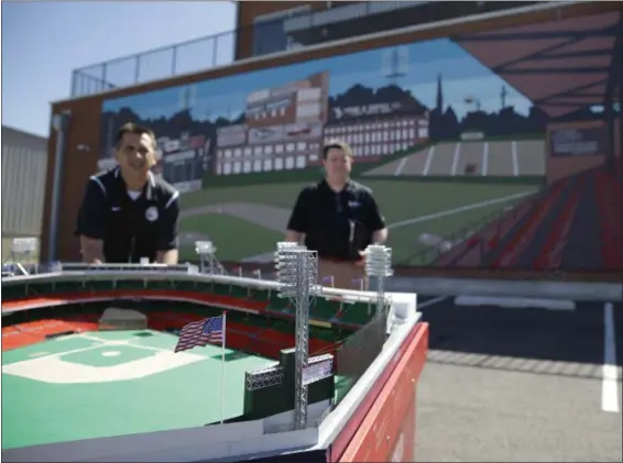  ?? JOHN MINCHILLO — THE ASSOCIATED PRESS ?? Workers prepare a miniature model of Crosley Field beside a newly unveiled mural at the Crosley Field Historic Site at the City Gospel Mission in Cincinnati on June 8. The site opened to visitors on property where the Cincinnati Reds for decades played...