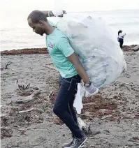  ?? FILE ?? Someone else’s problem: A volunteer carrying some of the thousands of plastic bottles taken from the Palisadoes beach during the Internatio­nal Coastal Cleanup Day last year.