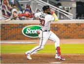  ?? BRYNN ANDERSON AP ?? Atlanta’s Marcell Ozuna hits a double against the Marlins. He also had two homers and drove in five.