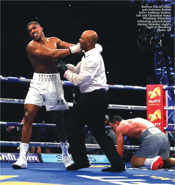  ?? Photo: AP ?? Referee David Fields gets between British boxer Anthony Joshua, left and Ukrainian boxer Wladimir Klitschko following a knockdown during Saturday night’s fight at Wembley