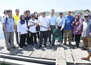  ??  ?? Awang Tengah (fourth left, first row) and other members of the delegation at the fish farm.