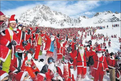  ?? [VALENTIN FLAURAUD/KEYSTONE] ?? The alpine skiing resort of Verbier, Switzerlan­d, brings together a collection of Santa Clauses and St. Nicholases on Saturday to celebrate the opening of the skiing season.