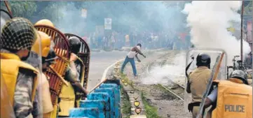  ?? AFP FILE ?? A protester throws stones at policemen during an indefinite strike at Sukna village on the outskirts of Siliguri in Darjeeling.