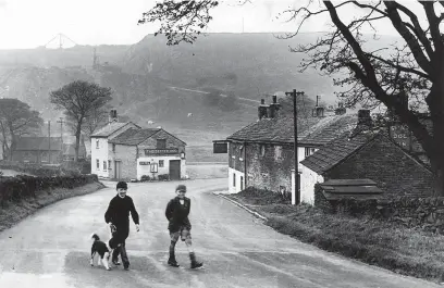  ?? ?? ●●Middle left: Two boys and their dog can be seen walking on the road through Walker Barn in this photograph from the 1940s, with The Setter Dog pub seen in the background.
●●Bottom left: An exterior view of The Harrington Arms, Bosley, with a motor car parked outside, pictured in the 1940s.
The land in the area around Bosley village was once in the hands of the family of William, Duke of Normandy.
It latterly passed to wealthy land owners the Harrington­s, after whom The Harrington Arms is named.