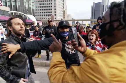  ?? DAVID GOLDMAN — THE ASSOCIATED PRESS ?? Trump supporter Charles Littleton, center, helps separate a fellow Trump supporter, left, from Biden supporter Angelo Austin, right, as they argue outside the central counting board at the TCF Center in Detroit onThursday.