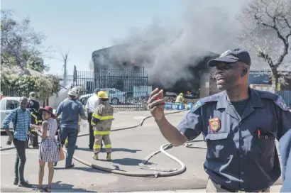  ?? Picture: Yeshiel Panchia ?? Police and firefighte­rs respond to a fire at a paint store on Soutter Street in Pretoria West yesterday. The fire was compounded by flammable paints and thinners in the building.