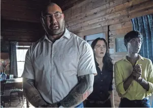  ?? UNIVERSAL PICTURES ?? Leonard (Dave Bautista, left), Adriane (Abby Quinn) and Sabrina (Nikki Amuka-Bird) disrupt a family’s vacation with a dreadful choice in M. Night Shyamalan’s thriller “Knock at the Cabin.”