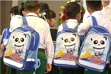  ??  ?? STUDENTS carry school bags with panda images during the ceremony for the 2019 Panda Pack donation and the 4th anniversar­y of China Foundation for Poverty Alleviatio­n Myanmar Office in Yangon.