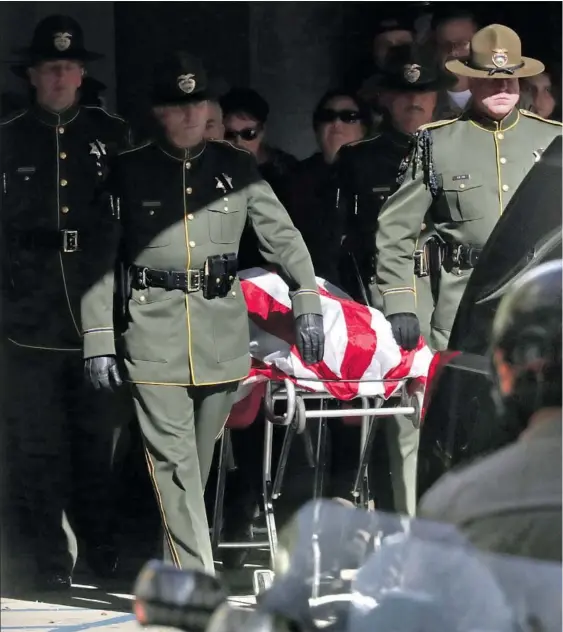  ??  ?? THE BODY of Ventura County Sheriff ’s Sgt. Ron Helus, covered by an American f lag, is escorted to a hearse at Los Robles Regional Medical Center in Thousand Oaks. “I’m going to miss him terribly. I really can’t believe he’s gone,” a neighbor said of the 54-year-old Helus.