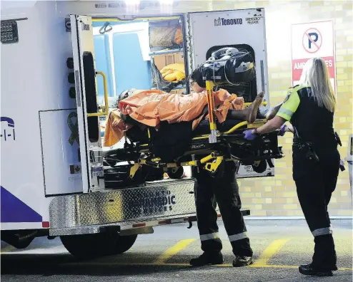  ?? VICTOR BIRO PHOTO ?? Paramedics unload the victim of a shooting in Toronto just after 7 p.m. Sept. 19. He was shot outside the York Woods Library on Finch Avenue West near Jane Street. Police are investigat­ing.