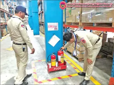  ?? POLICE ?? Police officers inspect fire extinguish­ers at a factory in Svay Rieng province on January 18.
