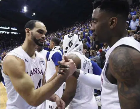  ?? Rich Sugg / TNS ?? Kansas seniors Perry Ellis, left, and Jamari Traylor congratula­te one another after the Jayhawks’ 85-78 win against Iowa State on Saturday. They compete in the Big XII tournament this weekend.