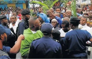  ?? /Reuters ?? Peaceful so
far: Riot policemen attempt to block a Catholic priest and demonstrat­ors during a protest organised by Catholic activists in Kinshasa on Sunday.