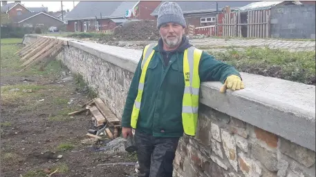  ??  ?? Dermot Maguire and the newly renovated wall at the former Ardee railway line.