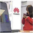  ?? FOTO: DPA ?? Eine Frau blickt auf ein Handy in einem Huawei-Store.