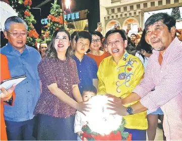  ??  ?? Dr Sim (second right), Ling (second left) and other officials launch the Merry Poppins Christmas celebratio­n by touching a glowing ball to light up a Christmas tree.