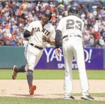  ?? Jeff Chiu / Associated Press ?? The Giants’ Evan Longoria is congratula­ted by thirdbase coach Ron Wotus after his solo homer in the seventh inning.