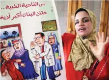  ?? A woman holds an FGM-awareness poster during a rally. ??