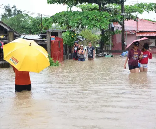  ?? SUNSTAR FOTO / ALLAN CUIZON ?? LILOAN FLOOD. Residents of Yati, Liloan are forced to go about their daily business in knee-deep water as a result of heavy rains.