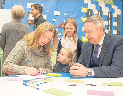  ?? Picture: Angus Findlay. ?? Councillor Angus Forbes with Esther McGoldrick, from Abernyte, and her daughters Anna, who is a P5 pupil, and Claire, 3, at the drop-in session at the primary school.