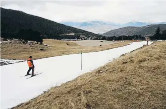  ?? ?? Un esquiador se desliza por una pista de nieve fabricada artificial­mente