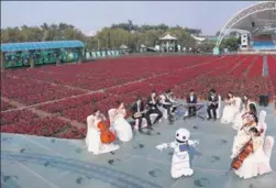  ?? XINHUA ?? Musicians play at a flower field in Nansha Free Trade Zone, Guangdong province, while a robot dances to their tunes.
