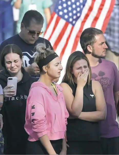  ?? Mark J. Terrill/Associated Press ?? People cry as a law enforcemen­t motorcade escorts the body of Ventura County Sheriff’s Department Sgt. Ron Helus from the Los Robles Regional Medical Center Thursday in Thousand Oaks, Calif., after a gunman opened fire Wednesday evening inside a country music bar, killing multiple people including Helus.