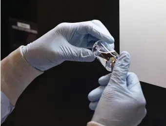  ?? AP FILE PHOTOS ?? SOMEWHAT EFFECTIVE: A vial of the drug remdesivir is inspected at a Gilead manufactur­ing site in March. The drug is thought to reduce recovery time for severe cases of the coronaviru­s from 15 to 11 days.