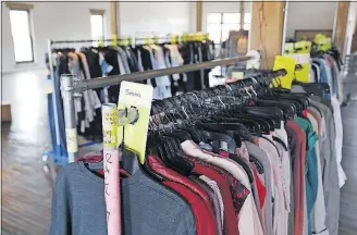  ?? [JOSHUA A. BICKEL/DISPATCH] ?? Express is sending its full-time teams of photograph­ers, videograph­ers, stylists, hair and makeup artists, copywriter­s and art directors to work in the renovated building. These racks of clothes are near the studio area.