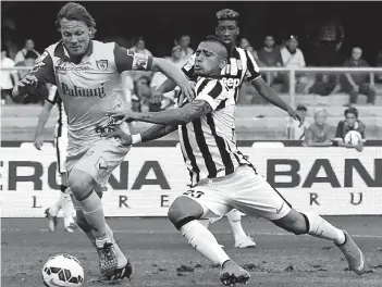  ?? — AFP ?? Juventus’ Arturo Vidal ( right) vies for the ball with Chievo Verona’s Nicolas Frey during their Serie A match at the Bentegodi Stadium in Verona on Saturday. Juventus won 1- 0.